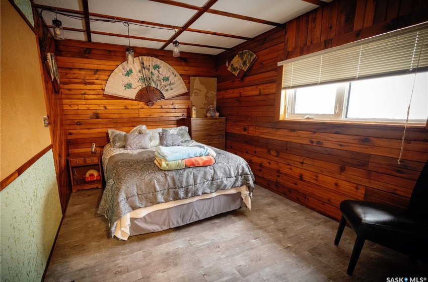 Bedroom featuring hardwood / wood-style floors and wooden walls