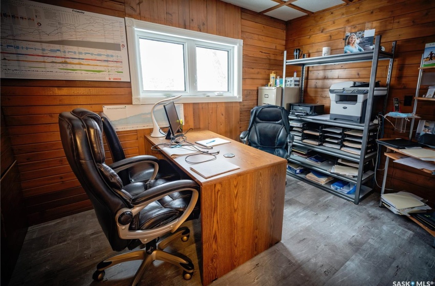 Office space featuring dark hardwood / wood-style flooring and wooden walls