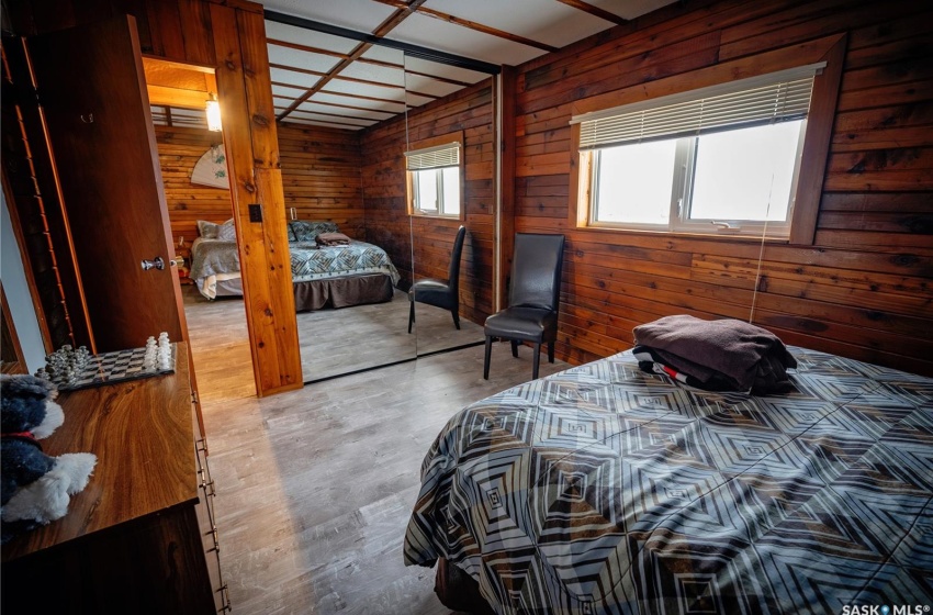 Bedroom featuring hardwood / wood-style floors, a closet, and wood walls