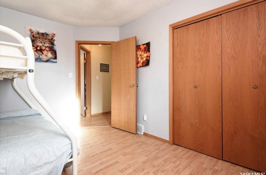 Bedroom with a textured ceiling, a closet, and light hardwood / wood-style floors