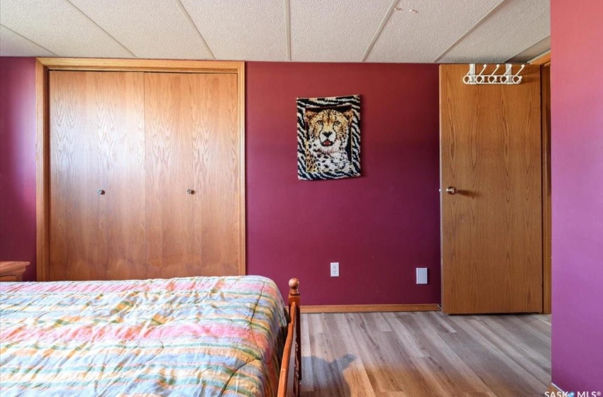 Bedroom featuring a closet, hardwood / wood-style floors, and a drop ceiling