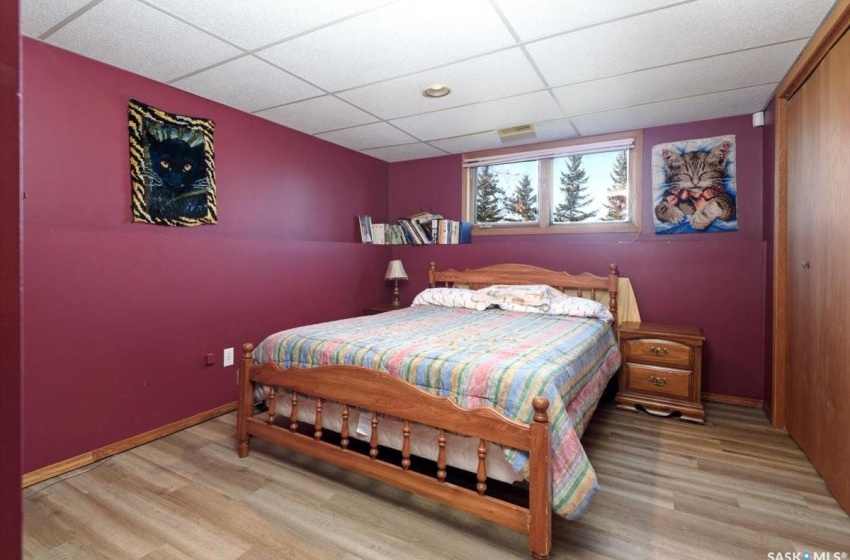 Bedroom featuring a closet, a paneled ceiling, and light hardwood / wood-style floors