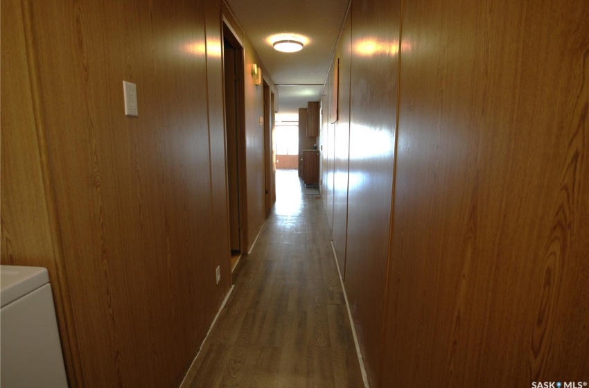 Hall with dark hardwood / wood-style flooring and washer / dryer