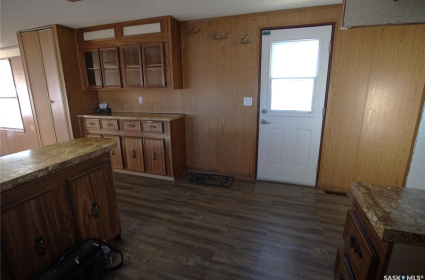 Kitchen with wooden walls and dark wood-type flooring