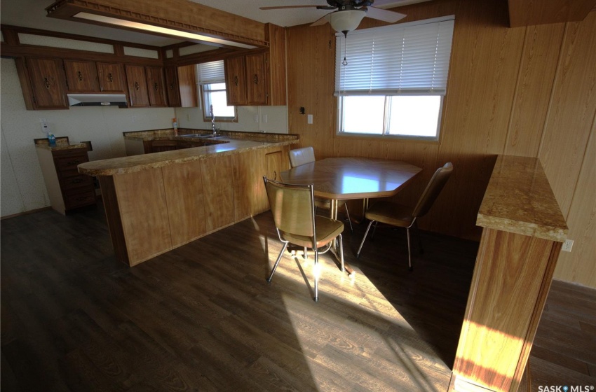 Kitchen featuring a wealth of natural light, dark hardwood / wood-style flooring, ceiling fan, and kitchen peninsula