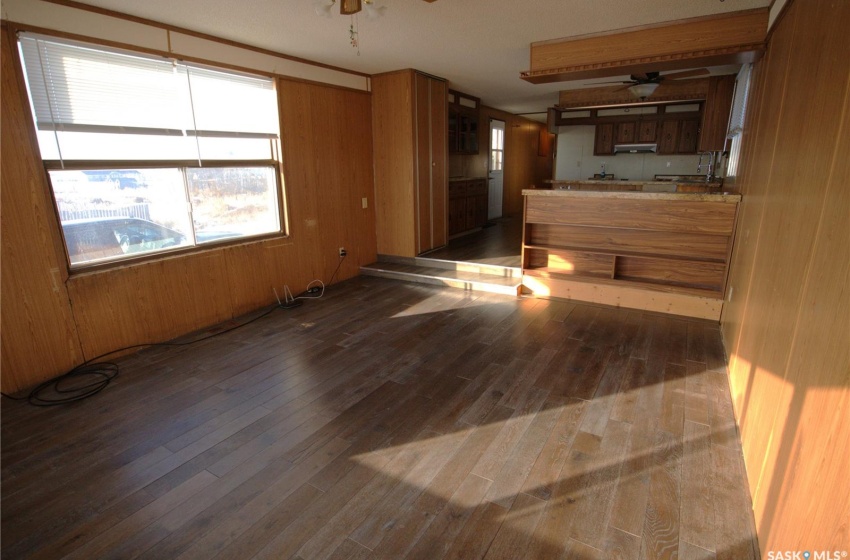 Spare room featuring dark hardwood / wood-style floors, wood walls, and ceiling fan