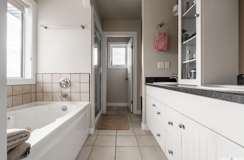 Bathroom with a bathtub, vanity, and tile floors