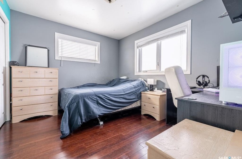 Bedroom with multiple windows and dark hardwood / wood-style flooring