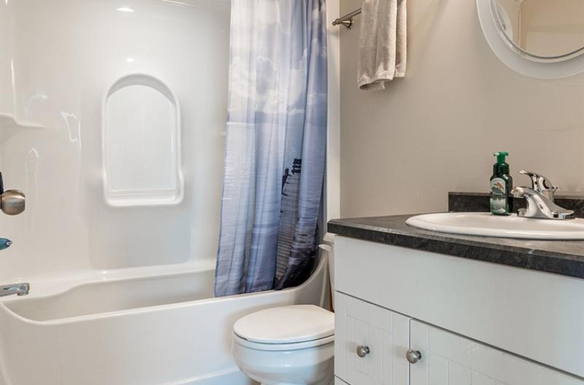 Full bathroom with vanity, toilet, shower / bath combo with shower curtain, and tile flooring