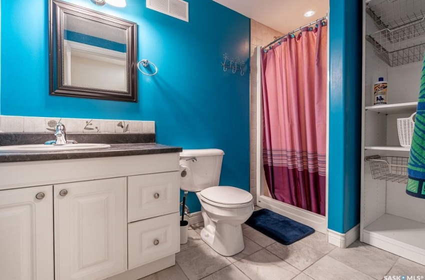 Bathroom featuring vanity, toilet, a shower with shower curtain, and tile flooring