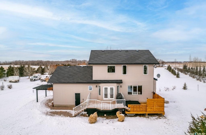 Snow covered property featuring a carport, a wooden deck, and french doors