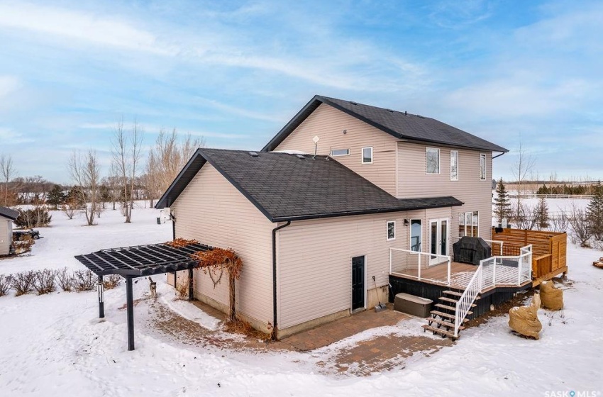 Snow covered back of property with a deck