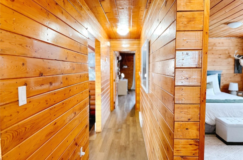 Hall featuring light hardwood / wood-style floors, wooden walls, and wooden ceiling