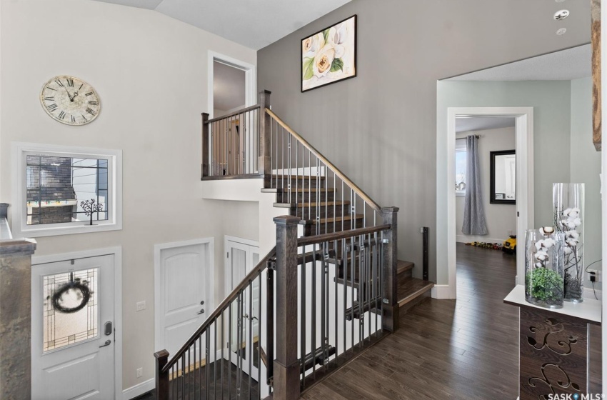 Stairway featuring a wealth of natural light, dark wood-type flooring, and a towering ceiling