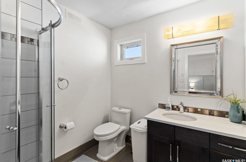 Bathroom with toilet, walk in shower, and vanity with extensive cabinet space