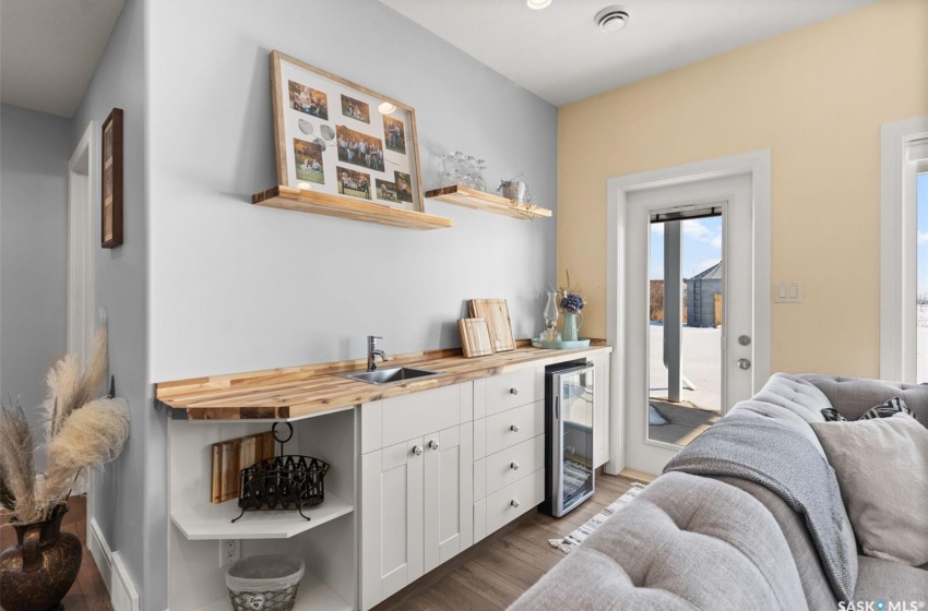 Kitchen with wine cooler, white cabinets, dark hardwood / wood-style flooring, sink, and wood counters