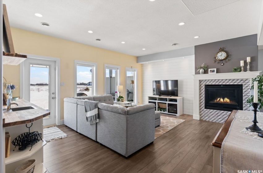 Living room with a fireplace, sink, and dark wood-type flooring