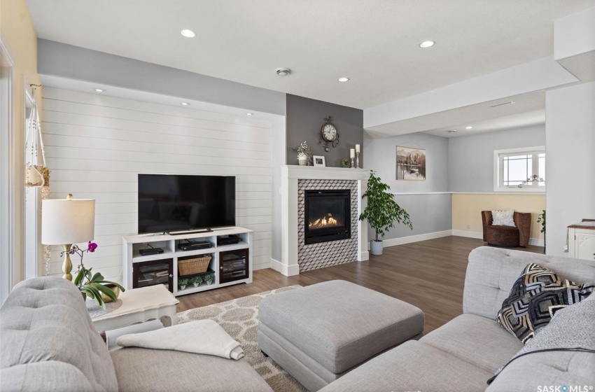 Living room with dark hardwood / wood-style floors and a tiled fireplace