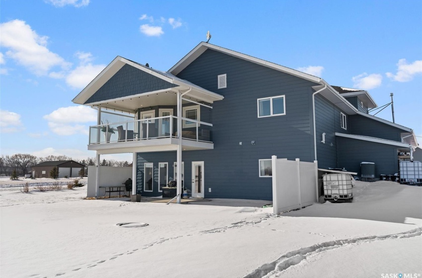 Snow covered rear of property with a balcony