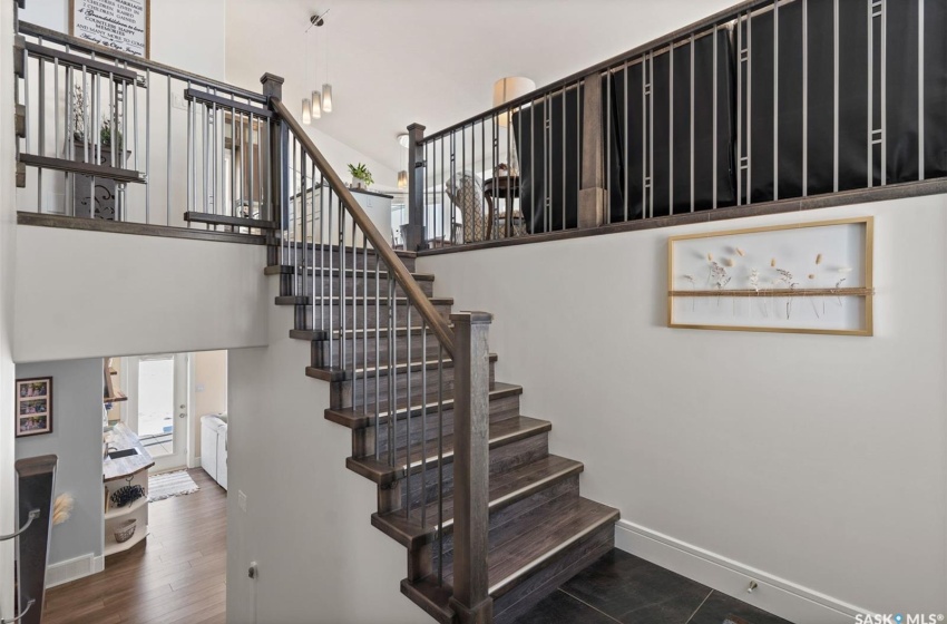 Staircase with dark hardwood / wood-style flooring and a towering ceiling