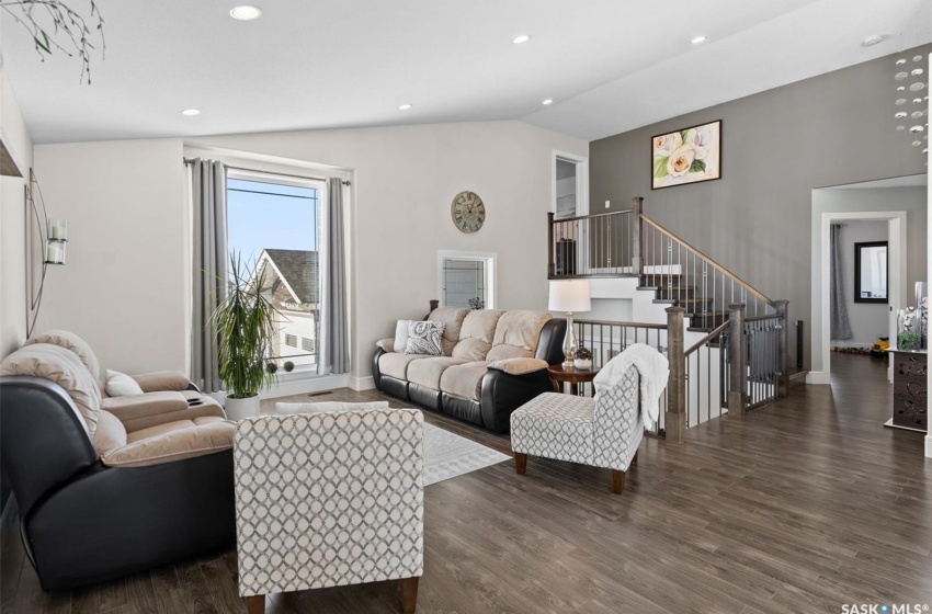 Living room with dark hardwood / wood-style floors and high vaulted ceiling