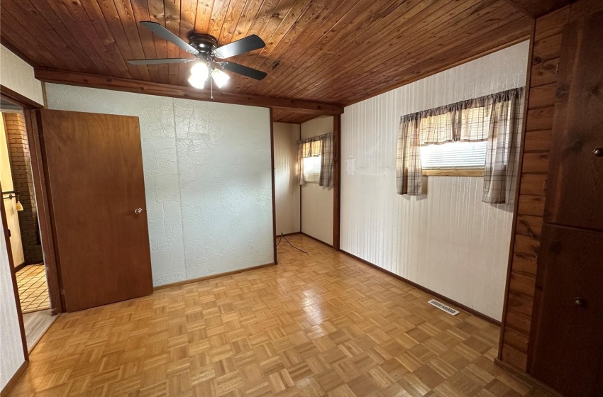 Spare room with wood ceiling, ceiling fan, and light parquet flooring