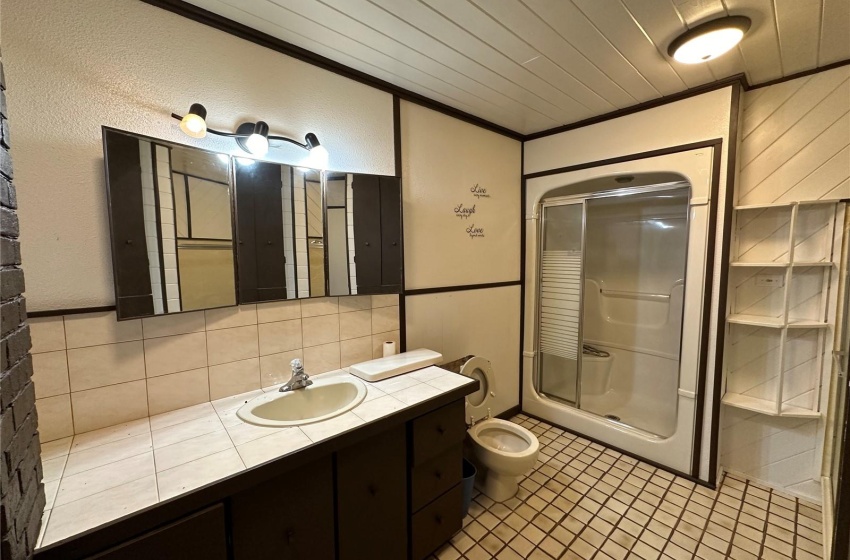 Bathroom with large vanity, an enclosed shower, crown molding, and toilet