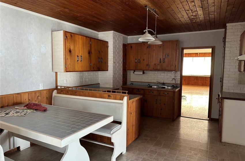 Kitchen with hanging light fixtures, wooden ceiling, ornamental molding, and sink