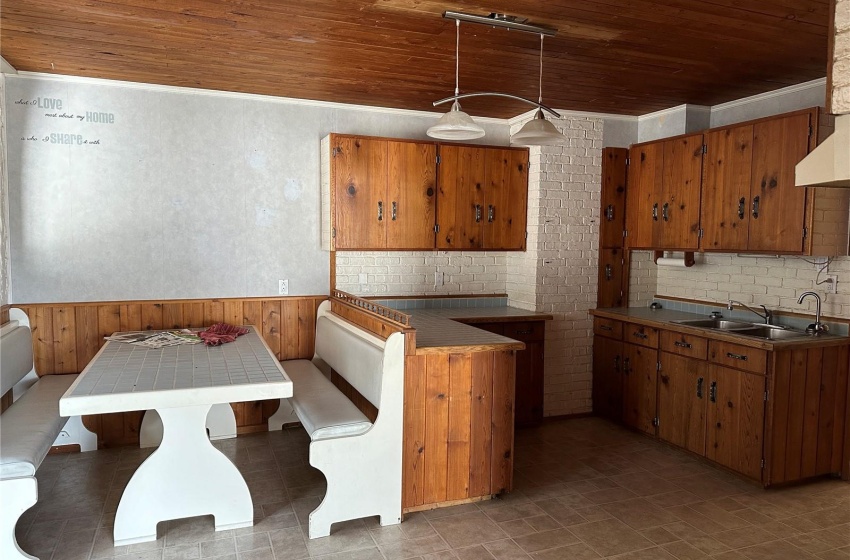 Kitchen featuring sink, light tile floors, decorative light fixtures, and wooden ceiling