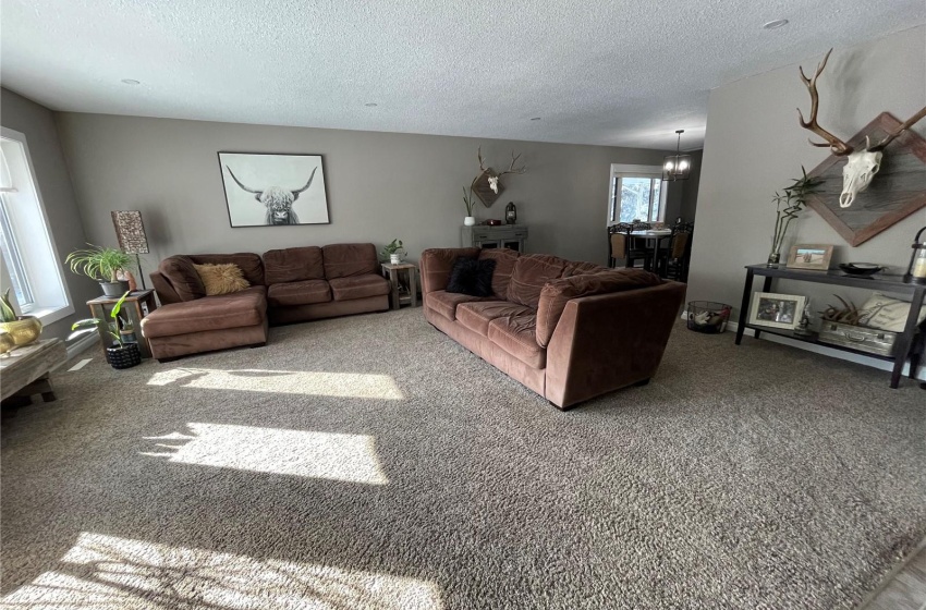 Living room with an inviting chandelier, carpet flooring, and a textured ceiling