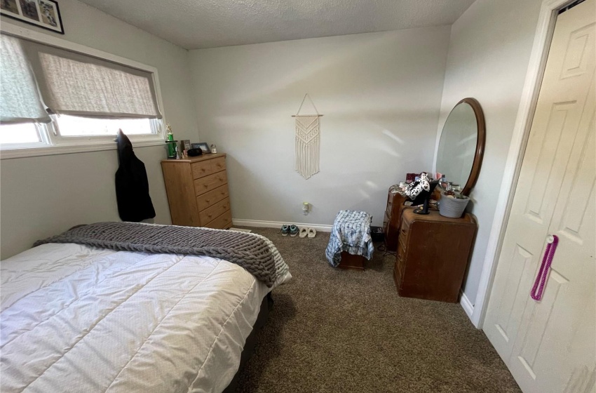 Bedroom with a textured ceiling and carpet