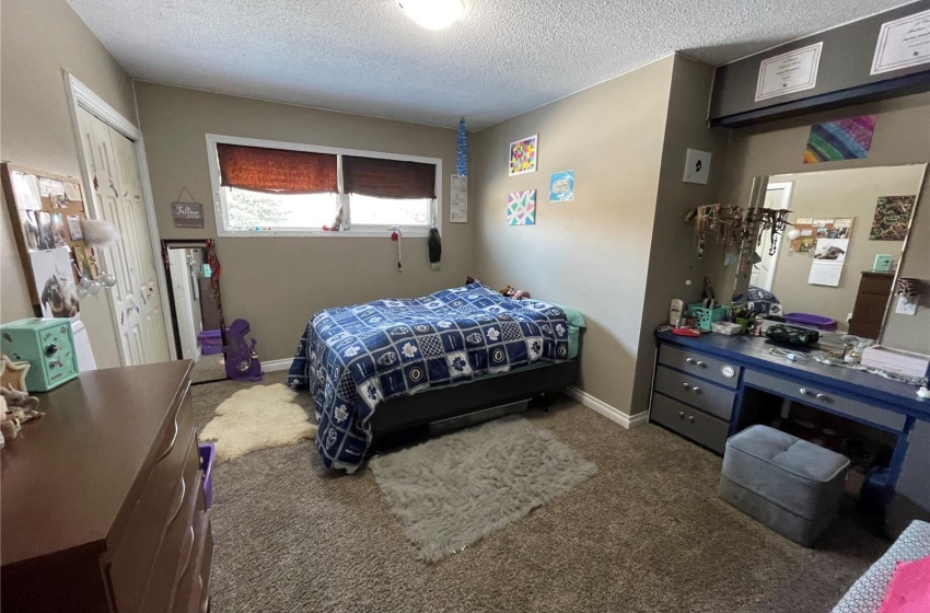 Carpeted bedroom with a closet and a textured ceiling