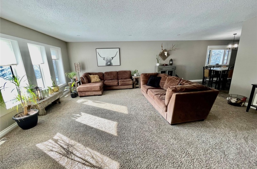 Living room with a chandelier, carpet floors, and a textured ceiling