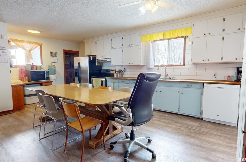 Kitchen featuring appliances with stainless steel finishes, light wood-type flooring, backsplash, and ceiling fan