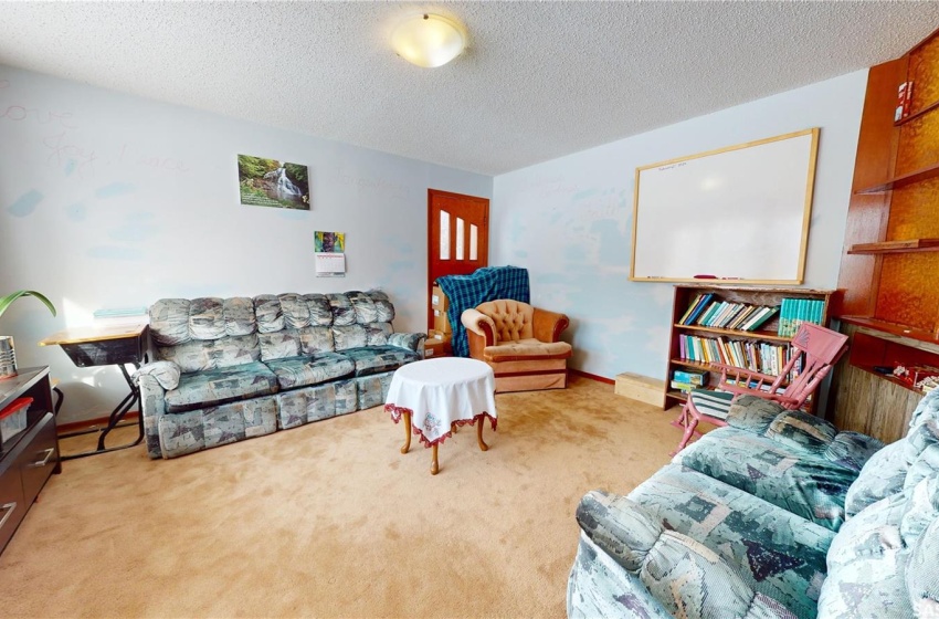 Carpeted living room with a textured ceiling