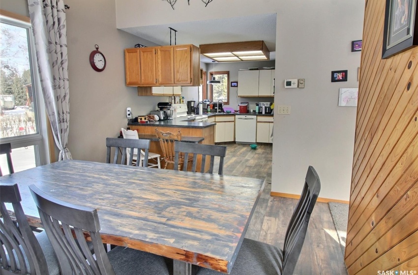 Dining space featuring vaulted ceiling and wooden separation wall