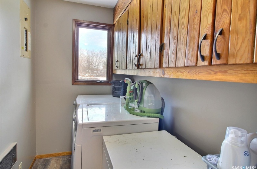 Laundry room with wood-type flooring, cabinets, and washing machine and clothes dryer