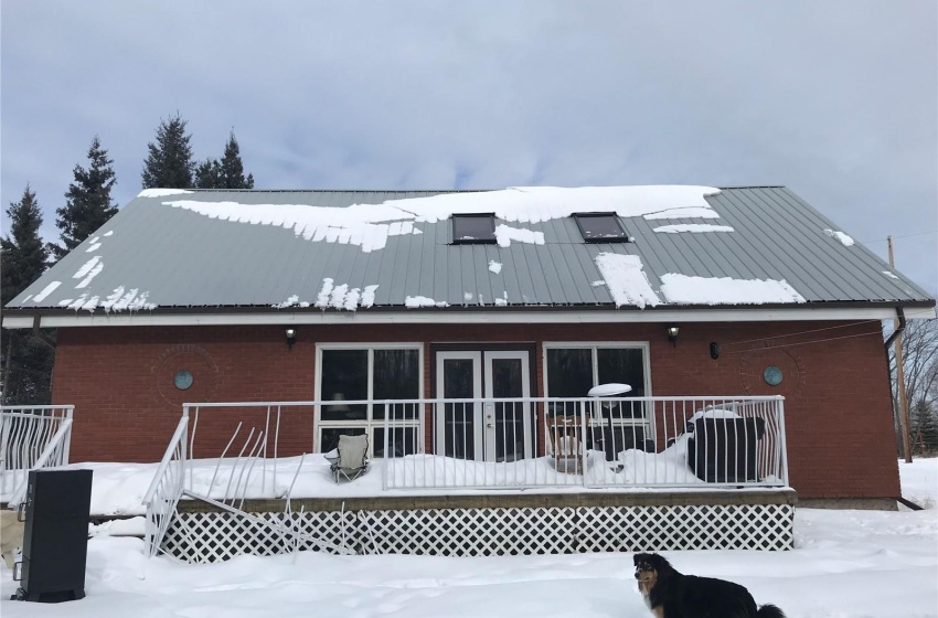 West side of house featuring a wooden deck and deck doors