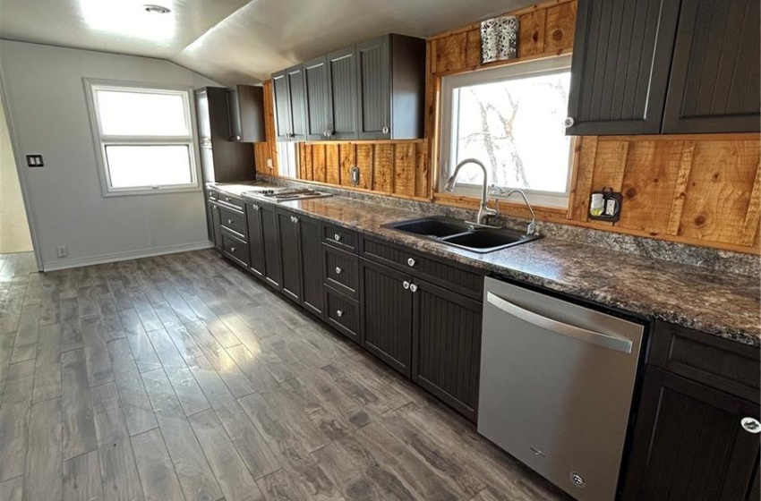 Kitchen with sink, fridge, dark hardwood / wood-style flooring, a barn door, and wall oven