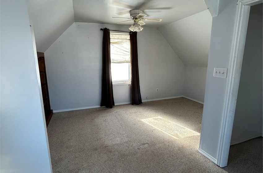 Unfurnished bedroom with ceiling fan and wooden walls