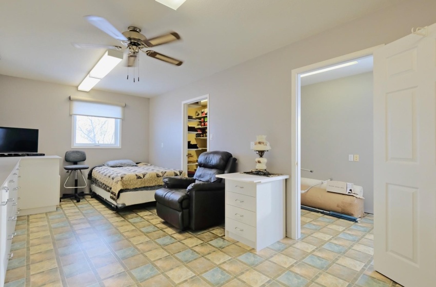 Tiled bedroom featuring a spacious closet, a closet, and ceiling fan