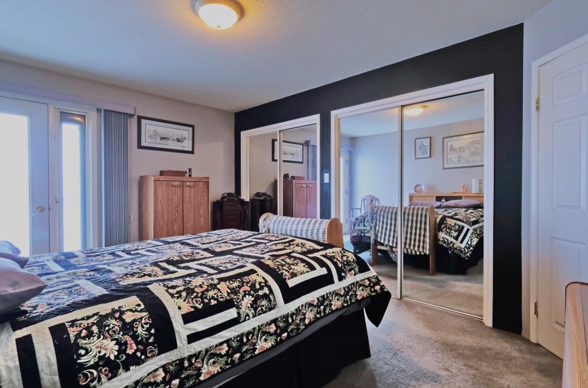 Bedroom featuring french doors, carpet floors, and multiple closets