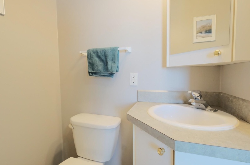 Bathroom with toilet and vanity with extensive cabinet space