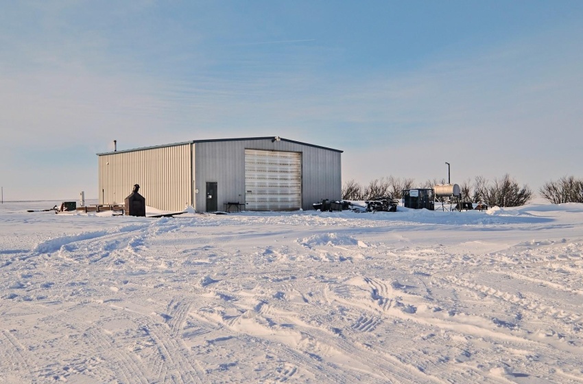 Snow covered structure featuring a garage