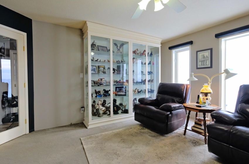 Carpeted living room featuring ceiling fan