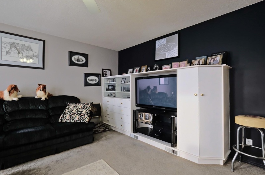 Carpeted living room featuring ceiling fan