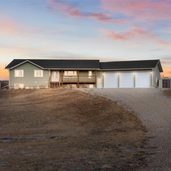 View of front of house featuring an outdoor structure, a garage, and a wooden deck