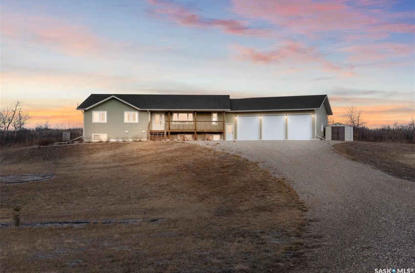 View of front of house featuring an outdoor structure, a garage, and a wooden deck