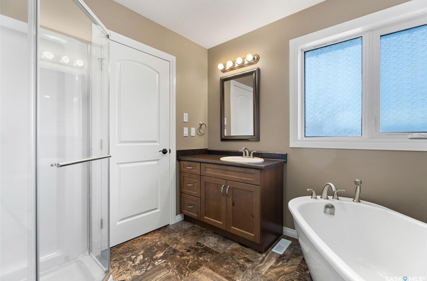 Bathroom featuring tile flooring, plus walk in shower, and vanity