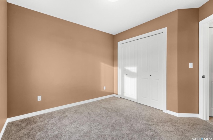 Unfurnished bedroom with light colored carpet and a closet